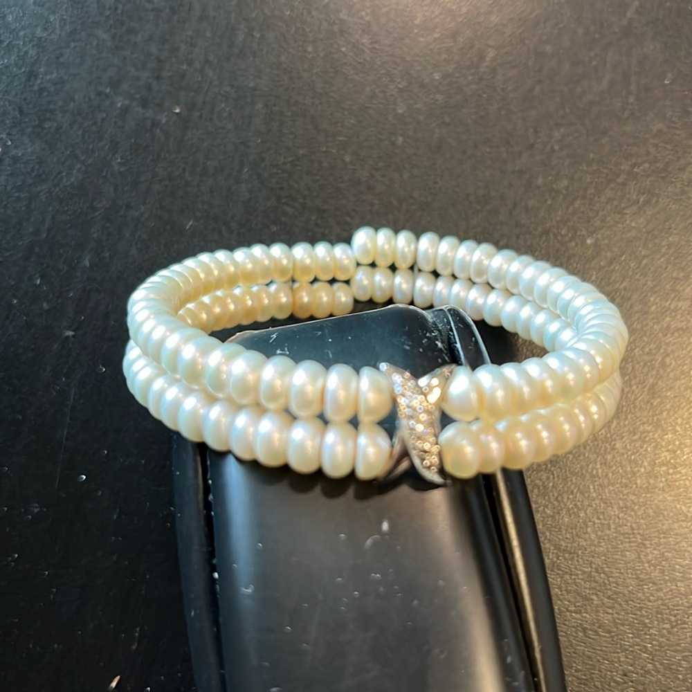 Elasticized pearl bracelet with rhinestone embellishment in a silver “x”